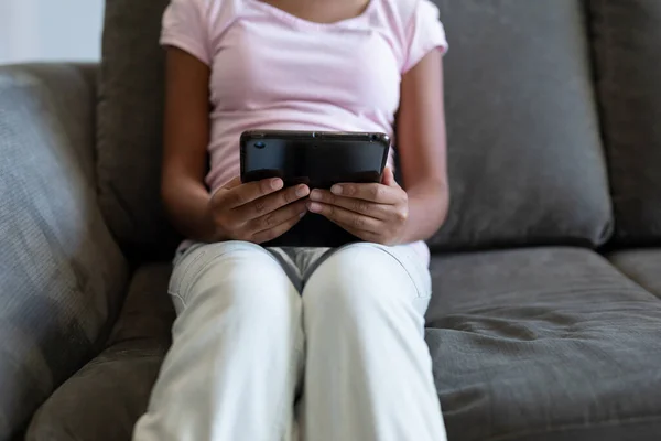 Mittelteil Des Mädchens Sitzt Auf Der Couch Mit Digitalem Tablet — Stockfoto