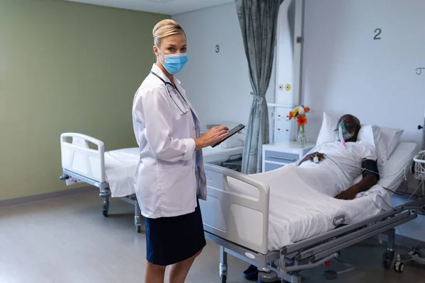 Vit Kvinnlig Läkare Bär Ansiktsmask Hålla Tablett Tittar Kameran Sjukhusets — Stockfoto