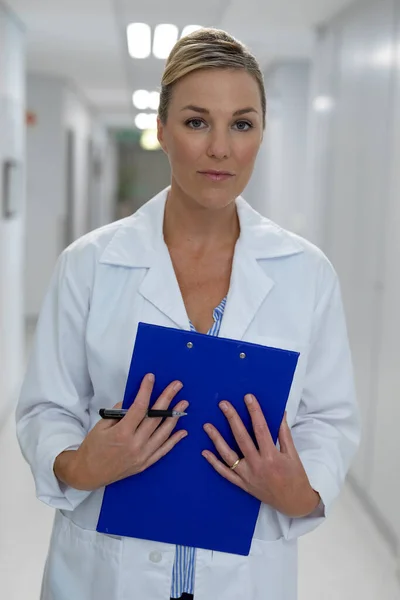 病院の廊下に立っている白人女性医師の肖像画は 医療チャート文書を保持しています 医療サービス — ストック写真