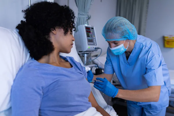Blanke Vrouwelijke Arts Het Ziekenhuis Draagt Gezichtsmasker Vaccineren Afrikaanse Amerikaanse — Stockfoto