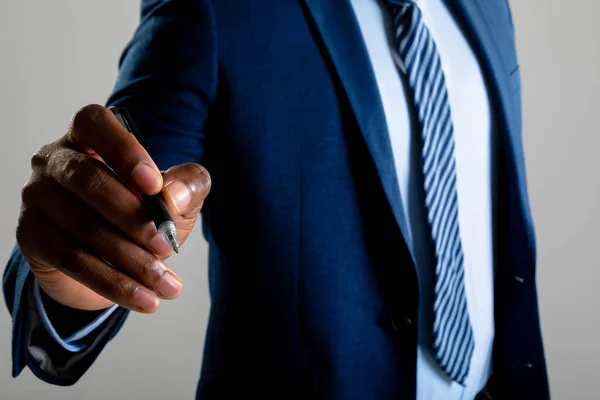 Mittelteil Des Geschäftsmannes Der Auf Unsichtbarem Bildschirm Vor Grauem Hintergrund — Stockfoto