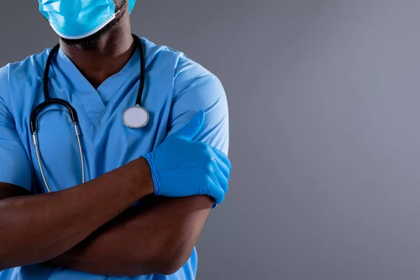 アフリカ系アメリカ人男性の健康労働者の中央部は灰色の背景にフェイスマスクを着用している 医療と医療のプロフェッショナリズムの概念 — ストック写真