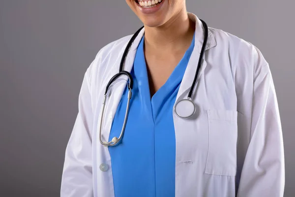 灰色の背景に笑顔アフリカ系アメリカ人女性医師の中央部 医療と医療のプロフェッショナリズムの概念 — ストック写真