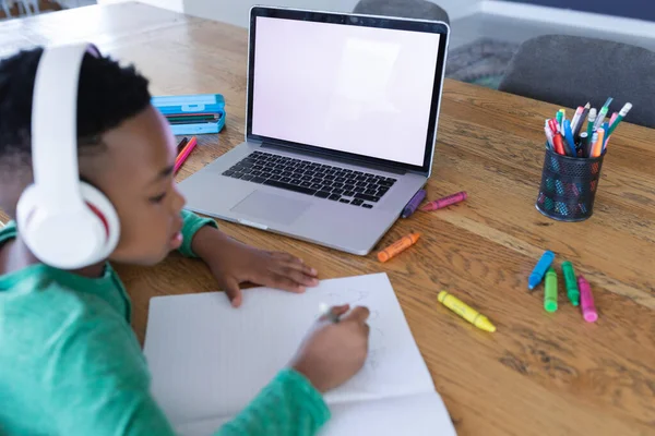 非洲裔美国男孩在网上上课 使用耳机和笔记本电脑 复制屏幕上的空间 在隔离检疫期间隔离在家 — 图库照片
