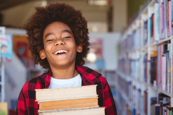 Nevető Afro Amerikai Iskolás Fiú Aki Könyveket Cipel Iskolai Könyvtárban — Stock Fotó