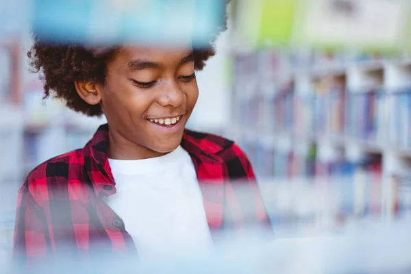 学校の図書館に立って本を読んでいるアフリカ系アメリカ人の少年を笑う 子供の頃と小学校での教育は — ストック写真