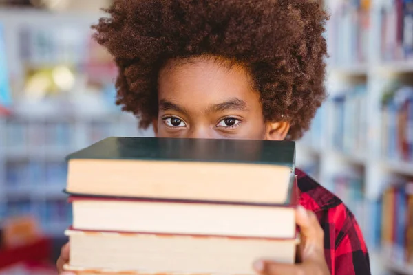 学校図書館に本を積んだアフリカ系アメリカ人の少年の肖像画 子供の頃と小学校での教育は — ストック写真