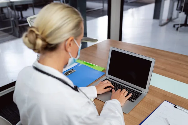 Médico Femenino Caucásico Con Máscara Facial Sentado Escritorio Oficina Del — Foto de Stock