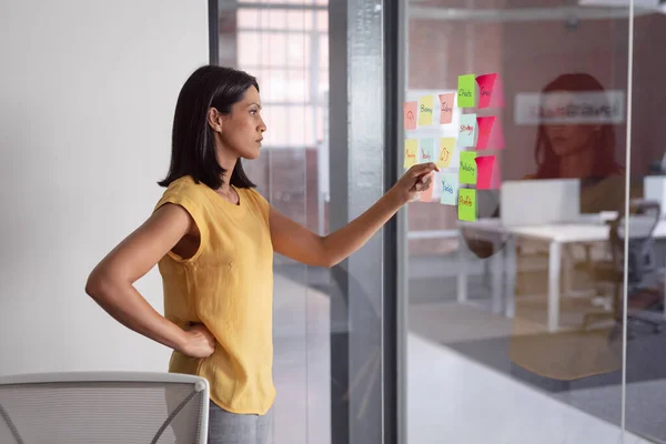 Thoughtful Caucasian Businesswoman Office Brainstorming Reading Memo Notes Glass Wall — Stock Photo, Image