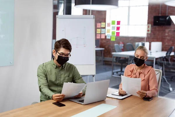Maskeli Çeşitli Erkek Kadın Meslektaşlar Ellerinde Dizüstü Bilgisayarlarıyla Oturmuş Evrak — Stok fotoğraf