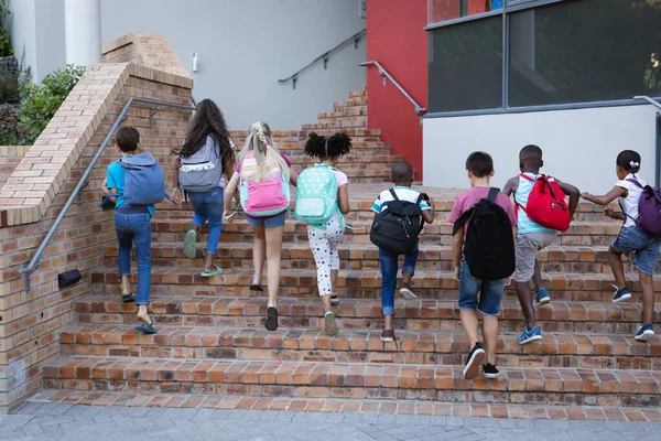 Visão Traseira Grupo Estudantes Diversos Com Mochilas Subindo Escadas Juntos — Fotografia de Stock