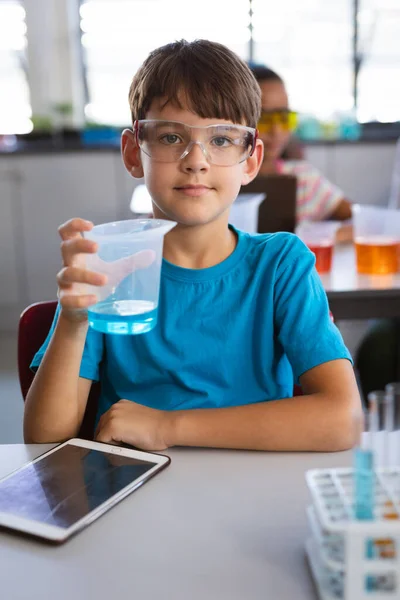 在实验室的科学课上 一个白人男孩拿着一个装满化学物质的烧杯的画像 学校和教育概念 — 图库照片