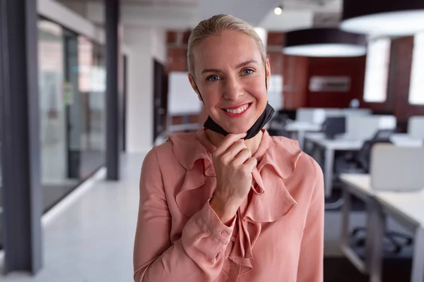 Portrait Caucasian Businesswoman Wearing Lowered Face Mask Standing Office Smiling — Stock Photo, Image