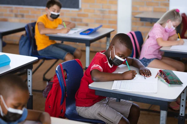 Menino Afro Americano Usando Máscara Facial Estudando Enquanto Estava Sentado — Fotografia de Stock