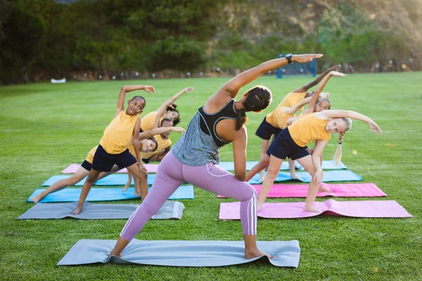 Insegnante Femminile Gruppo Studenti Diversi Che Eseguono Esercizio Stretching Giardino — Foto Stock