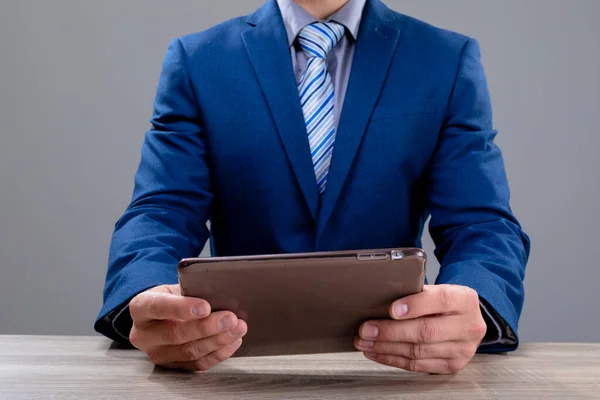 Kafkas Işadamının Orta Kesiminde Gri Arka Planda Izole Edilmiş Tablet — Stok fotoğraf