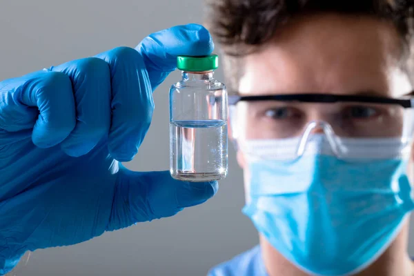 Caucasian Male Doctor Wearing Face Mask Safety Glasses Holding Vaccine — Stock Photo, Image