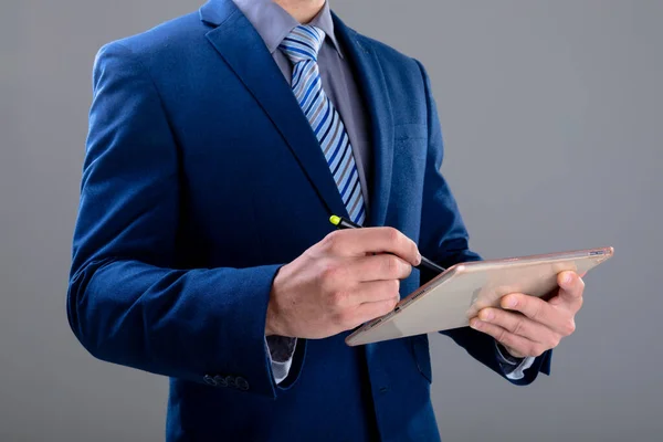 Kafkas Işadamının Orta Kesiminde Gri Arka Planda Izole Edilmiş Tablet — Stok fotoğraf