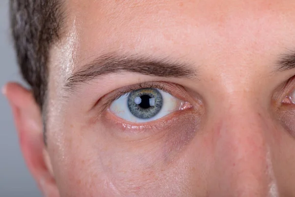 灰色の背景に隔離された白人ビジネスマンの青い目のクローズアップ ビジネス技術コミュニケーション成長の概念 — ストック写真
