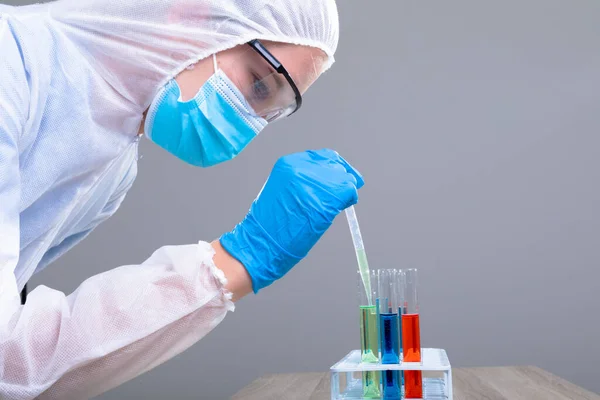 Doctora Caucásica Vistiendo Traje Ppe Sosteniendo Tubos Ensayo Concepto Tecnología —  Fotos de Stock