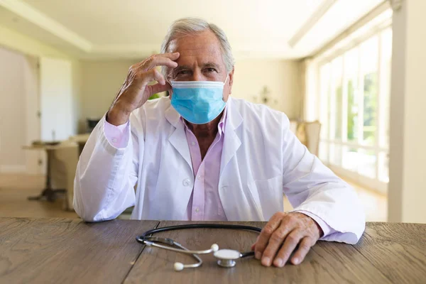 Starszy Kaukaski Lekarz Noszący Maskę Twarzy Podczas Rozmowy Wideo Medycyna — Zdjęcie stockowe