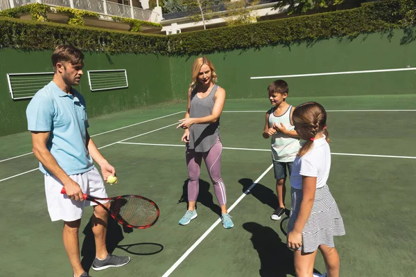 一对快乐的高加索夫妇 女儿和儿子在户外 在网球场打网球 与家人一起参加康健的康乐活动 — 图库照片