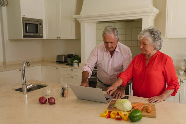 Senior Pareja Caucásica Cocinar Juntos Uso Ordenador Portátil Cocina Retiro —  Fotos de Stock