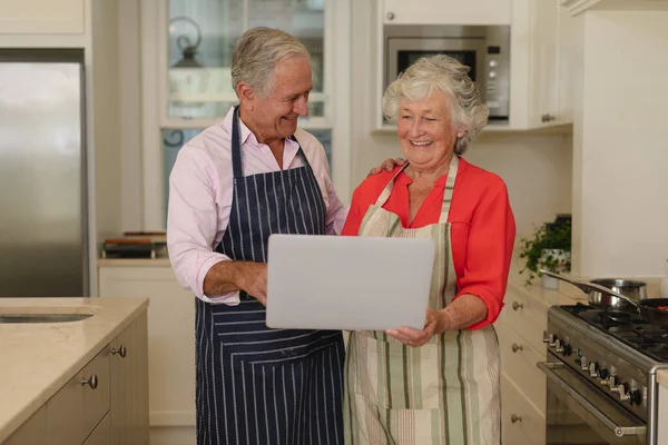 Senior Pareja Caucásica Utilizando Ordenador Portátil Juntos Cocina Retiro Jubilación —  Fotos de Stock