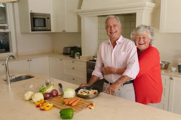 キッチンで一緒に調理し 笑顔のシニア白人夫婦の肖像画 隠遁と退職と幸せなシニアライフスタイルのコンセプト — ストック写真