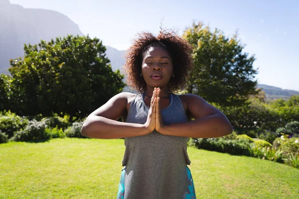 Afrika Kökenli Amerikalı Kadın Gözleri Kapalı Güneşli Bahçede Yoga Yapıyor — Stok fotoğraf