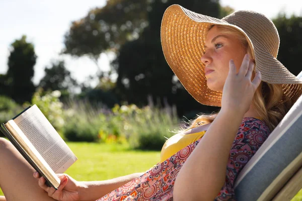 Mujer Caucásica Con Sombrero Sol Relajante Tumbona Libro Lectura Jardín — Foto de Stock