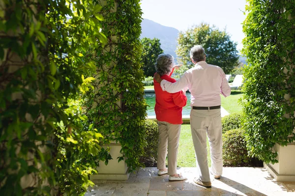 Coppia Caucasica Anziana Che Abbraccia Parla Giardino Soleggiato Ritiro Pensionamento — Foto Stock