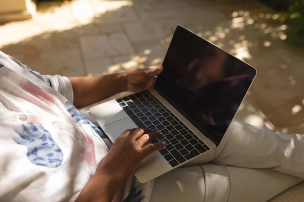 Środkowa Część Starszej Afrykańskiej Kobiety Używającej Laptopa Zacienionym Tarasie Słonecznym — Zdjęcie stockowe