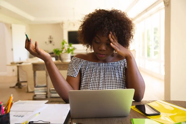 アフリカ系アメリカ人の女性は ラップトップを使用してリビングルームで働いて集中しています テクノロジーとコミュニケーション家からの柔軟な働き方 — ストック写真