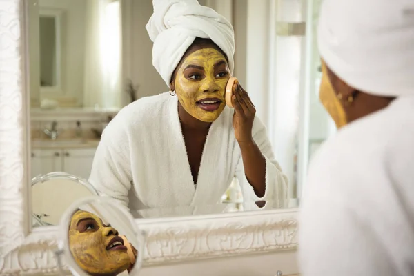 Šťastná Africká Američanka Koupelně Ručníkem Hlavě Dívá Zrcadla Obličejovou Maskou — Stock fotografie