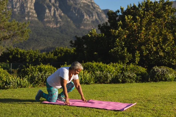 Senior African American Woman Kneeling Yoga Mat Grass Stunning Countryside — Stok fotoğraf
