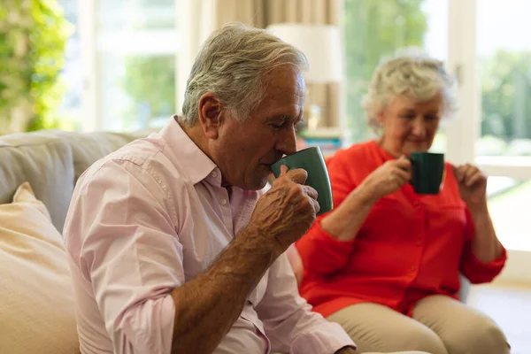 Senior Kaukasiska Par Sitter Soffan Tillsammans Dricka Kaffe Vardagsrummet Reträtt — Stockfoto