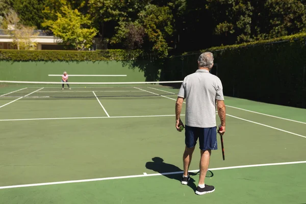 资深的高加索夫妇在球场上一起打网球 退休务虚会和积极的老年生活方式概念 — 图库照片