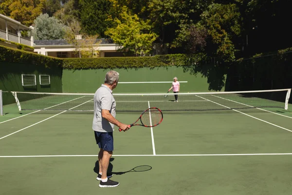 资深的高加索夫妇在球场上一起打网球 退休务虚会和积极的老年生活方式概念 — 图库照片