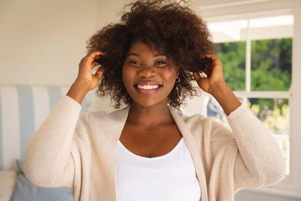 Retrato Mulher Afro Americana Sorridente Tocando Seu Cabelo Sentado Cama — Fotografia de Stock