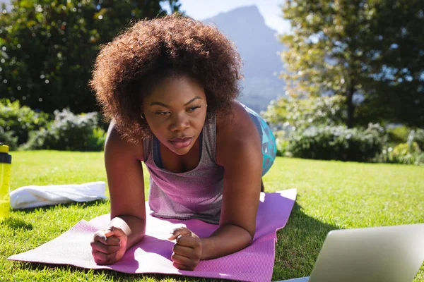 Mujer Afroamericana Haciendo Ejercicio Haciendo Tablón Esterilla Yoga Jardín Soleado —  Fotos de Stock