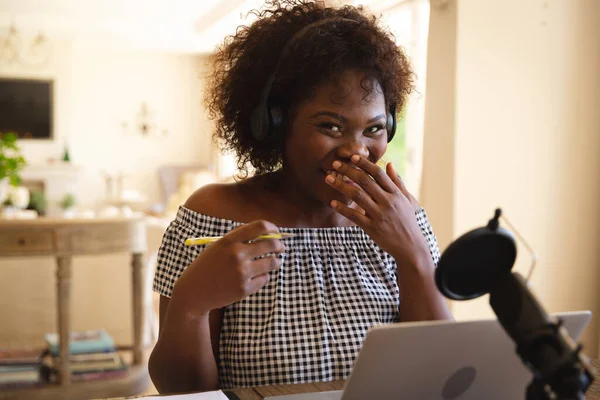 快乐的非洲裔美国女人 戴着耳机 用麦克风 在播客时大笑 技术和通信 国内网上播客 — 图库照片
