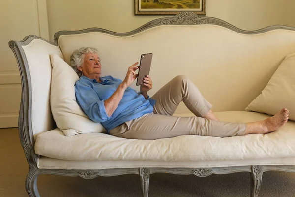 Seniorin Liegt Auf Sofa Und Benutzt Tablet Rückzug Ruhestand Und — Stockfoto