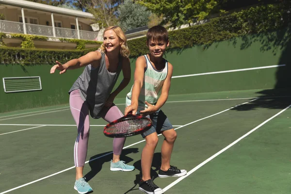 白人母亲和儿子在户外网球场打网球 与家人一起参加康健的康乐活动 — 图库照片