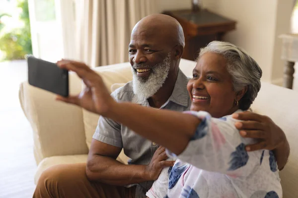 Starsza Afrykańska Para Siedząca Kanapie Używając Smartfona Robienia Selfie Wycofanie — Zdjęcie stockowe