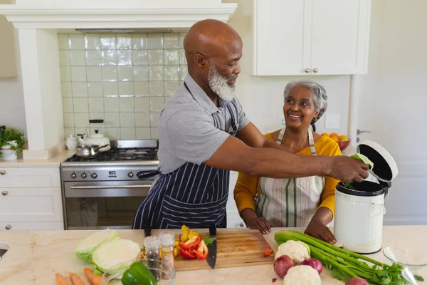 シニアアフリカ系アメリカ人の夫婦がキッチンで一緒に調理する笑顔 隠遁と退職と幸せなシニアライフスタイルのコンセプト — ストック写真