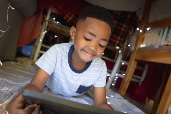 Boldog Afro Amerikai Fiú Otthon Egy Takaró Erődben Fekszik Táblagépet — Stock Fotó