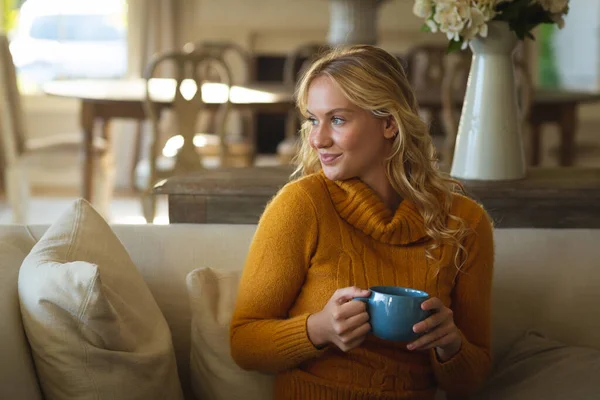 Mujer Caucásica Feliz Sentada Sofá Sala Estar Sosteniendo Taza Café — Foto de Stock