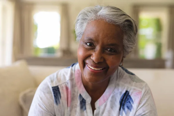 高级非洲裔美国妇女坐在沙发上看着相机笑的画像 退休和快乐的老年生活方式概念 — 图库照片
