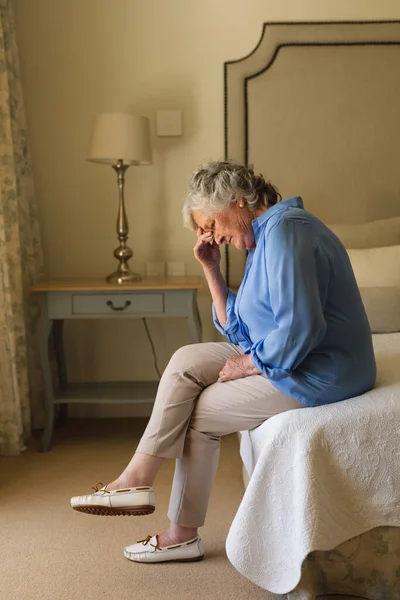 高个子的高加索女人抱着头坐在床上 在卧室里思考问题 退休和老年生活方式概念 — 图库照片